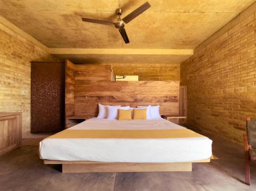 une chambre avec un lit et un ventilateur de plafond dans l'établissement Torrearena Design Hotel, à Puerto Escondido