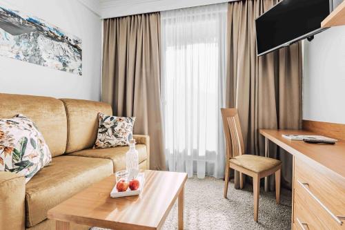 a living room with a couch and a table at SKI - GOLF - WELLNESS Hotel Riml in Hochgurgl