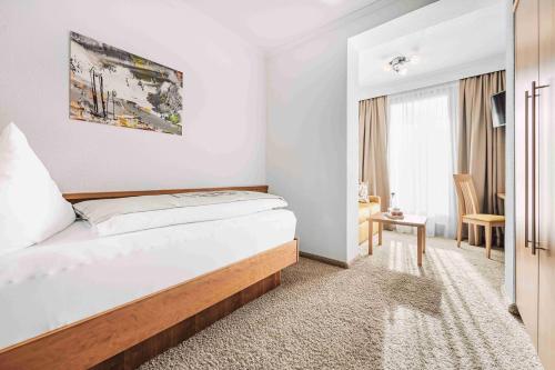 a hotel room with a bed and a window at SKI - GOLF - WELLNESS Hotel Riml in Hochgurgl