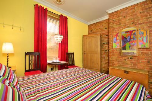a bedroom with a bed and a brick wall at Auberge Les Bons Matins in Montréal