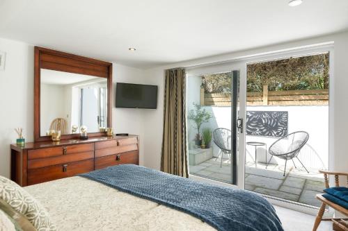 a bedroom with a bed and a television and a balcony at Ranalegh Court in Saint Columb Minor