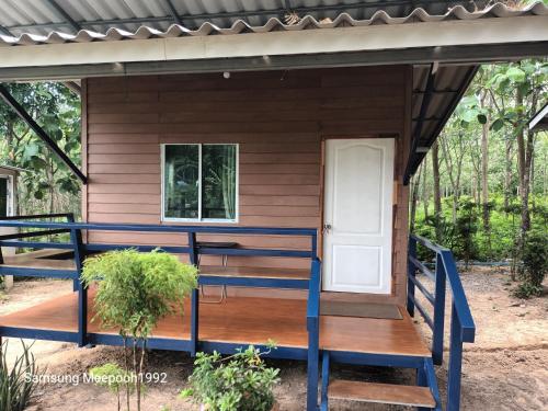a tiny house with a porch and a white door at PhaluayCamping in Koh Phaluai