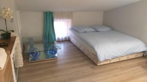 une chambre avec un lit et une fenêtre dans l'établissement Mon petit nid d'amour au cœur historique de Fréjus, à Fréjus