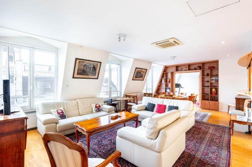 un salon avec deux canapés et une télévision dans l'établissement GuestReady - Spacious Comfort in the 8th, à Paris