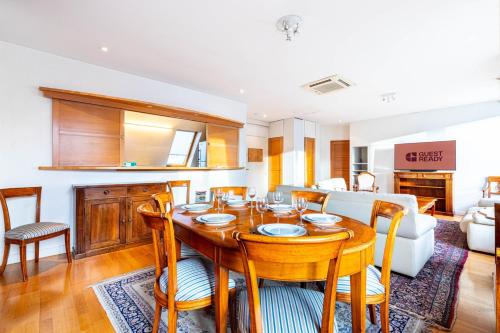 Il dispose d'une cuisine et d'un salon avec une table et des chaises en bois. dans l'établissement GuestReady - Spacious Comfort in the 8th, à Paris