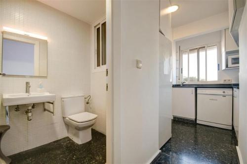Baño blanco con aseo y lavamanos en Beds & Breaks Gimenez, en Valencia