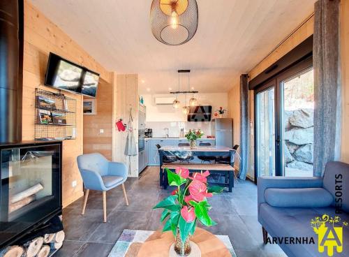 un salon avec un canapé bleu et une cuisine dans l'établissement Chalet de la Motte, à Chambon-sur-Lac