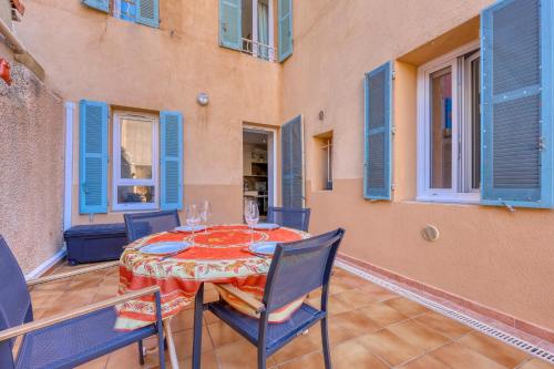 une salle à manger avec une table et des chaises dans l'établissement Le Patio du Port - Appt climatisé avec jardin, à Sanary-sur-Mer