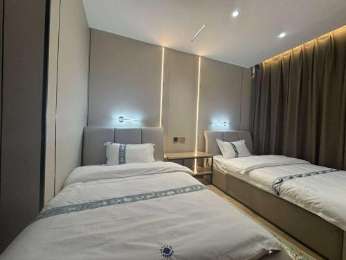 two beds in a small room with lights at Erkhes hotel in Dalandzadgad