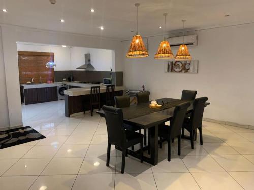 アクラにあるHuge 3 bed in heart of the city!のテーブルと椅子のあるキッチンとダイニングルーム