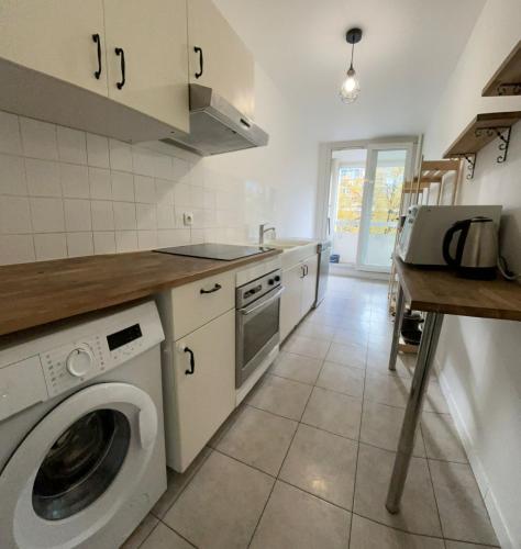 une cuisine avec une machine à laver et un lave-linge dans l'établissement Cozy 1BR apartment, 5mn to métro, in La Défense, à Courbevoie