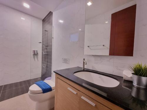 a bathroom with a sink and a toilet and a shower at The Golfers in Jomtien Beach