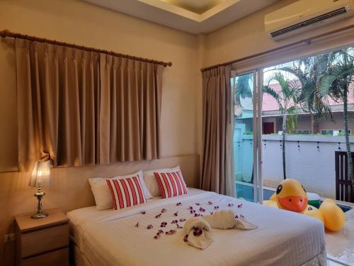 a bedroom with a bed and a window with flowers on it at The Golfers in Jomtien Beach