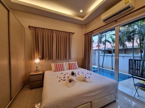 a bedroom with a bed and a large window at The Golfers in Jomtien Beach