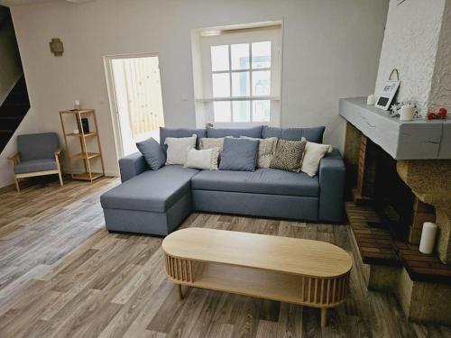 a living room with a blue couch and a coffee table at Appartement - Grande terrasse in Marsanne