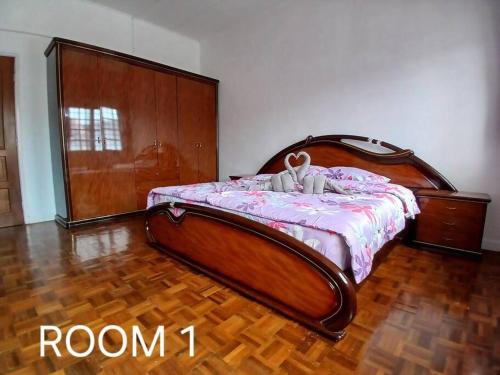 una camera da letto con un letto con testiera in legno di Cartoon world homestay a Seremban