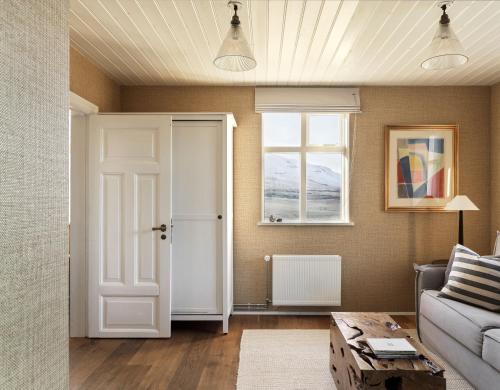 a living room with a white door and a window at Hvammsvík Nature Resort in Kjósahreppur