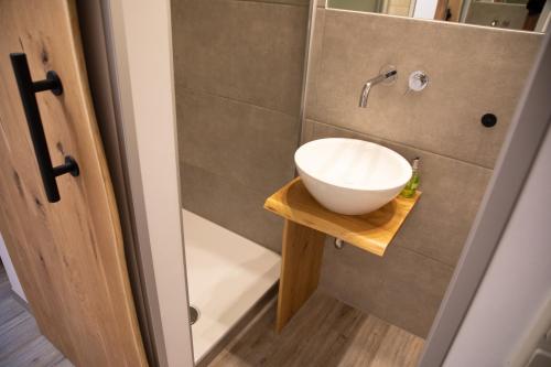 a bathroom with a white bowl sink on a wooden table at Hotel Weilerhof in Dormagen