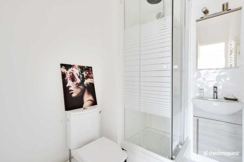 une salle de bain blanche avec toilettes et douche dans l'établissement Charming studio - 2P - Near Convention, à Paris
