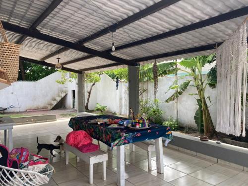 a patio with a table and a cat on a patio at Casa em Porto de Galinhas in Porto De Galinhas