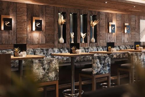 a restaurant with wooden walls and tables and chairs at SKI - GOLF - WELLNESS Hotel Riml in Hochgurgl