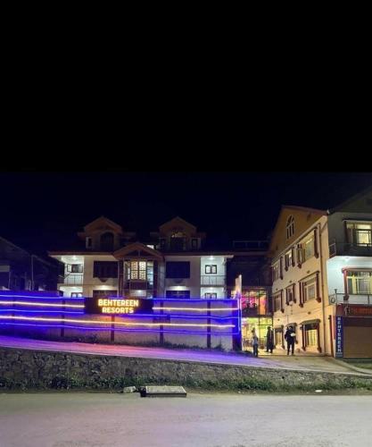 a group of buildings at night with blue lights at Behtereen Resorts in Srinagar