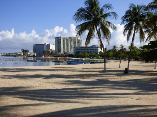 a sandy beach with palm trees and a city at Beach One Bedroom Suite A29 in Ocho Rios