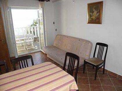 a living room with a couch and a table and chairs at Apartments Pondeljak in Malinska