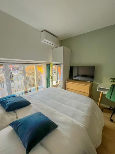 - un grand lit blanc avec des oreillers bleus dans une chambre dans l'établissement Cosy Studio Toulouse centre, à Toulouse