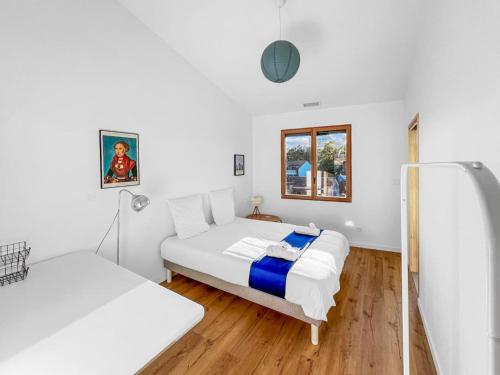 2 Betten in einem Zimmer mit weißen Wänden und Holzböden in der Unterkunft Grande Villa de 400m2 21 Personnes en centre ville de Toulouse in Toulouse