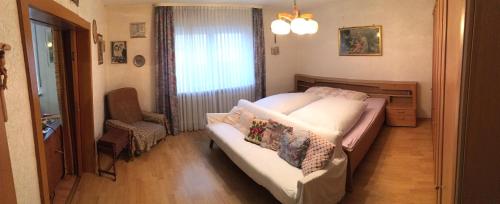 Un pequeño dormitorio con una cama y una silla. en Apartment Gosberg - 90qm, en Pinzberg