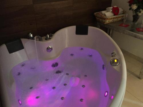a white bath tub with pink lighting in a bathroom at Palese Profumo di Mare in Santo Spirito