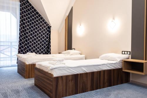 two beds in a room with white sheets at RIVER SIDE in Polyana
