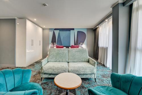 a living room with a couch and chairs and a bed at Juliana Hotel Cannes in Cannes