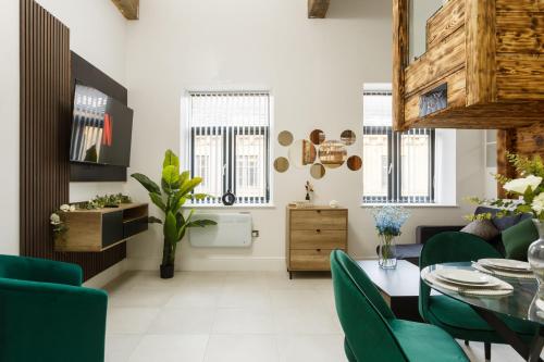 a living room with a table and green chairs at Bradford Luxury Central Apartment in Bradford