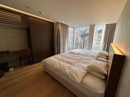 a bedroom with a bed and a large window at SuiShou in Kutchan