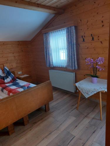 una habitación con una cama y una mesa y una ventana en Appartement Kirchner, en Kleinsonnberg