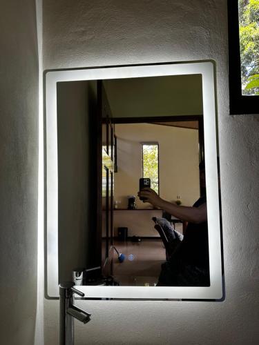 a person taking a picture of a mirror on a wall at Modern Loft inside a beautiful farm in General Viejo