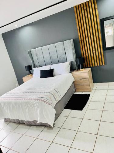 a bedroom with a large bed and a blue wall at Emanzini Self-catering guesthouse in Mtwalume