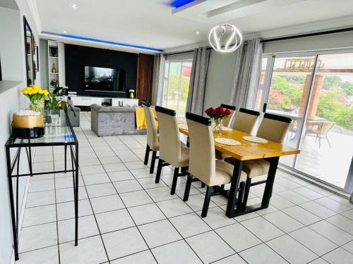a dining table and chairs in a living room at Emanzini Self-catering guesthouse in Mtwalume