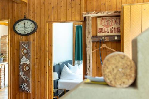 a room with a clock on the wall and a bed at Casa Christian in Partenen