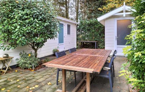a wooden picnic table in front of a shed at Stunning Home In Vorden With Wifi in Vorden