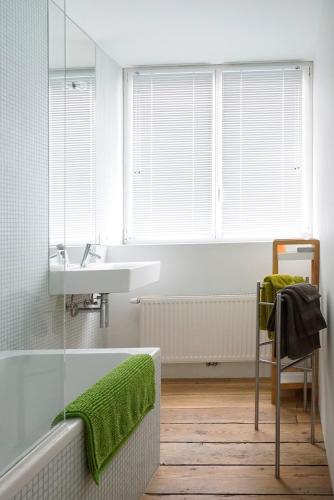 a bathroom with a tub and a sink and a window at B&B Home & the City in Brussels