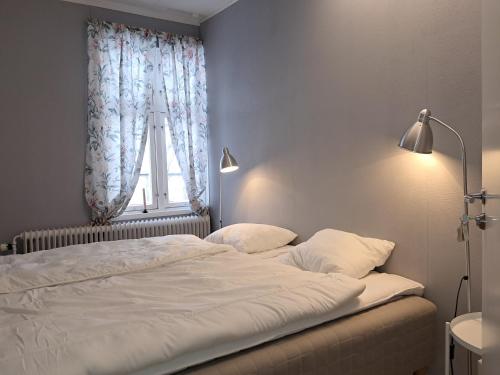 a bedroom with a large white bed with a window at Rutsbrogården in Rutån
