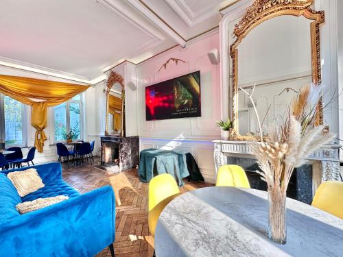 a living room with a blue couch and a table at MONACO Style Jungle - Tourcoing 01 in Tourcoing
