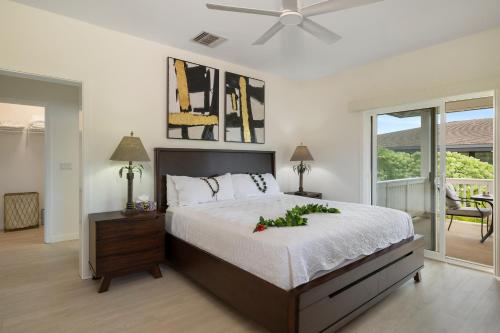 a bedroom with a bed with a flower arrangement on it at Coconut Plantation 1078-3 in Kapolei