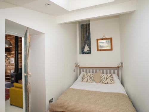a bedroom with a bed in a white room at Lle Te in Abersoch