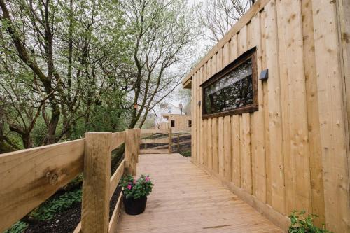 a wooden boardwalk leading to a building with a window at A Place In the Pennines in Huddersfield
