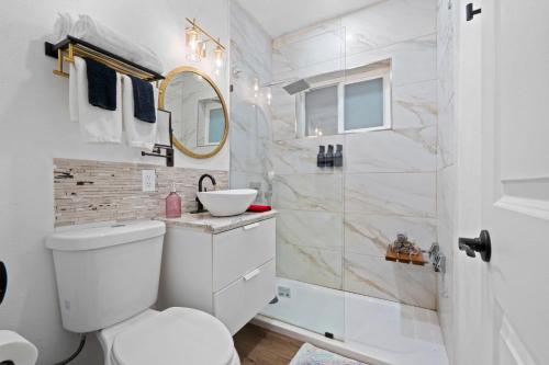 a bathroom with a white toilet and a shower at Stunning Little Havana Suites Close to airport, Calle Ocho, Brickell, Wynwood and the Beaches - Free Parking in Miami