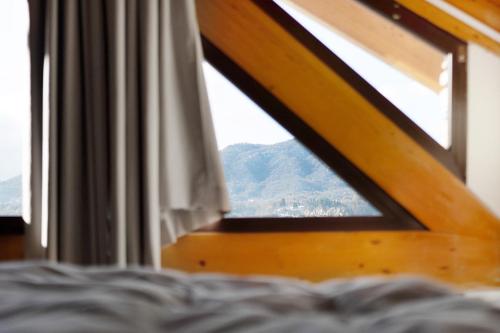 a bedroom window with a view of a mountain at Charmingly Renovated Stone House in Cesara